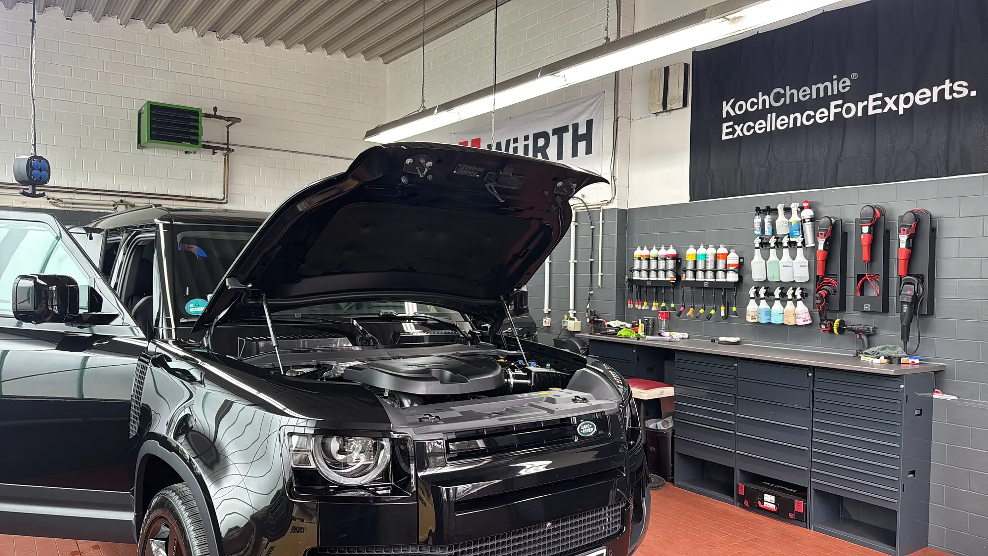 Land Rover Defender mit offener Motorhaube in der Fahrzeugaufbereitung von AutoPoint Gallinchen in Cottbus