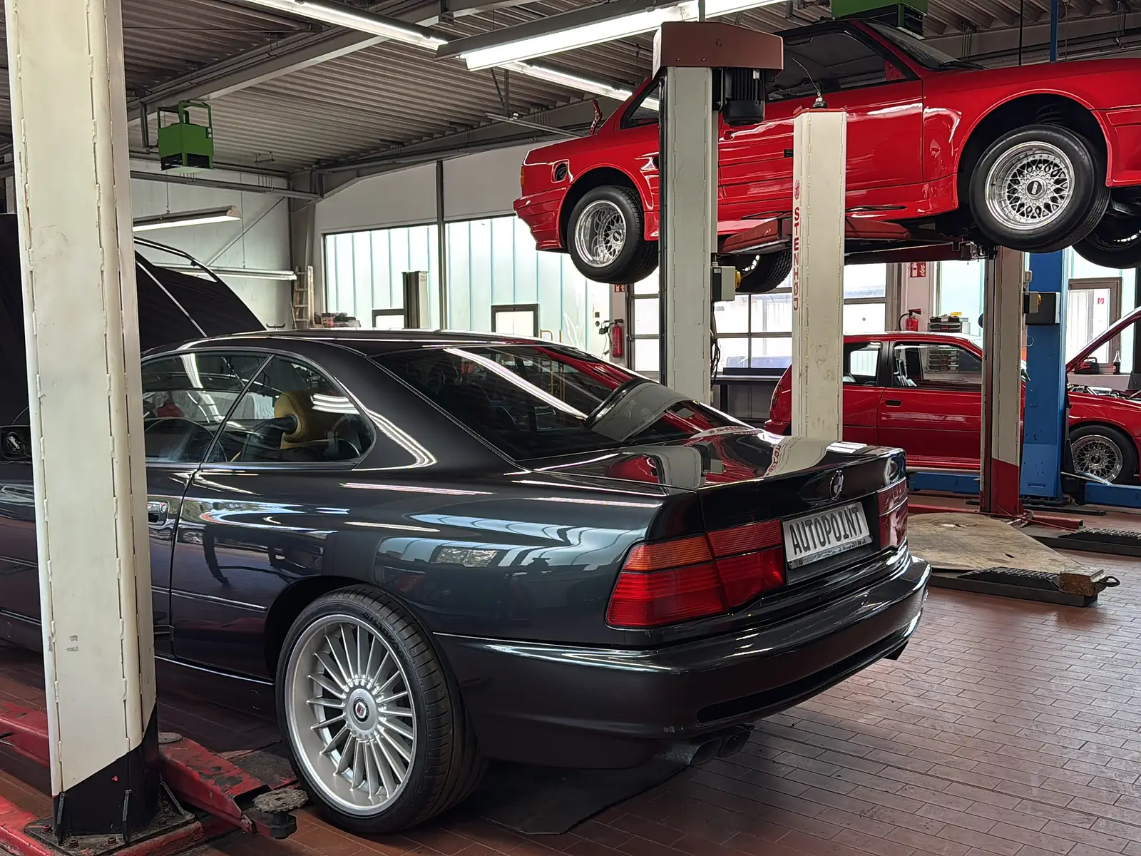 Werkstatt von AutoPoint Gallinchen mit BMW 8er und Youngtimer auf der Hebebühne