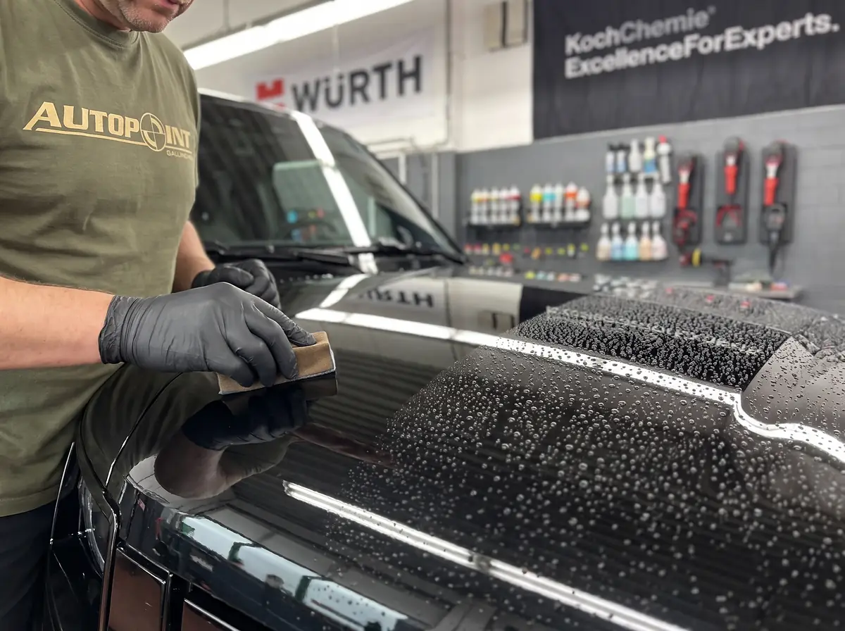 Keramikversiegelung wird auf die Motorhaube eines Land Rover Defender aufgetragen