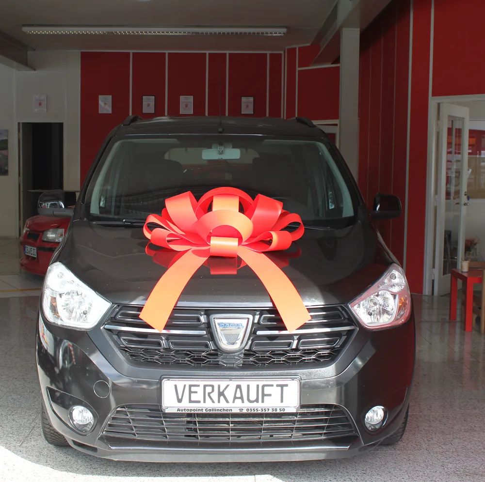 Verkaufter Gebrauchtwagen mit roter Schleife im Showroom von AutoPoint Gallinchen