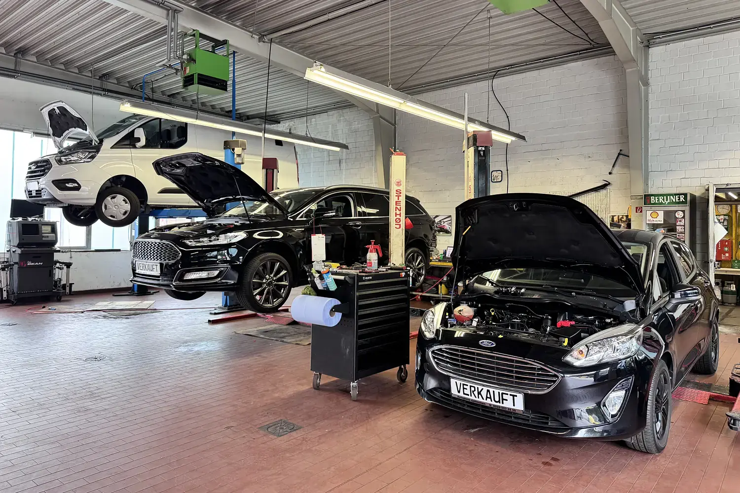 Fahrzeuge mit geöffneter Motorhaube und auf der Hebebühne in der Werkstatt von AutoPoint Gallinchen